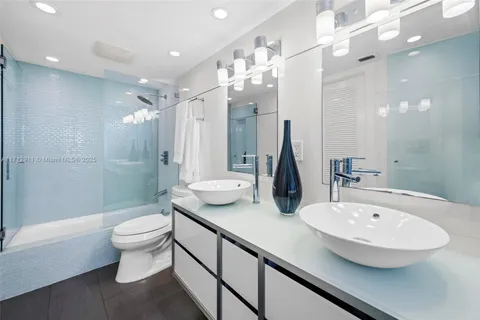 a bathroom with a double vanity sink toilet and shower