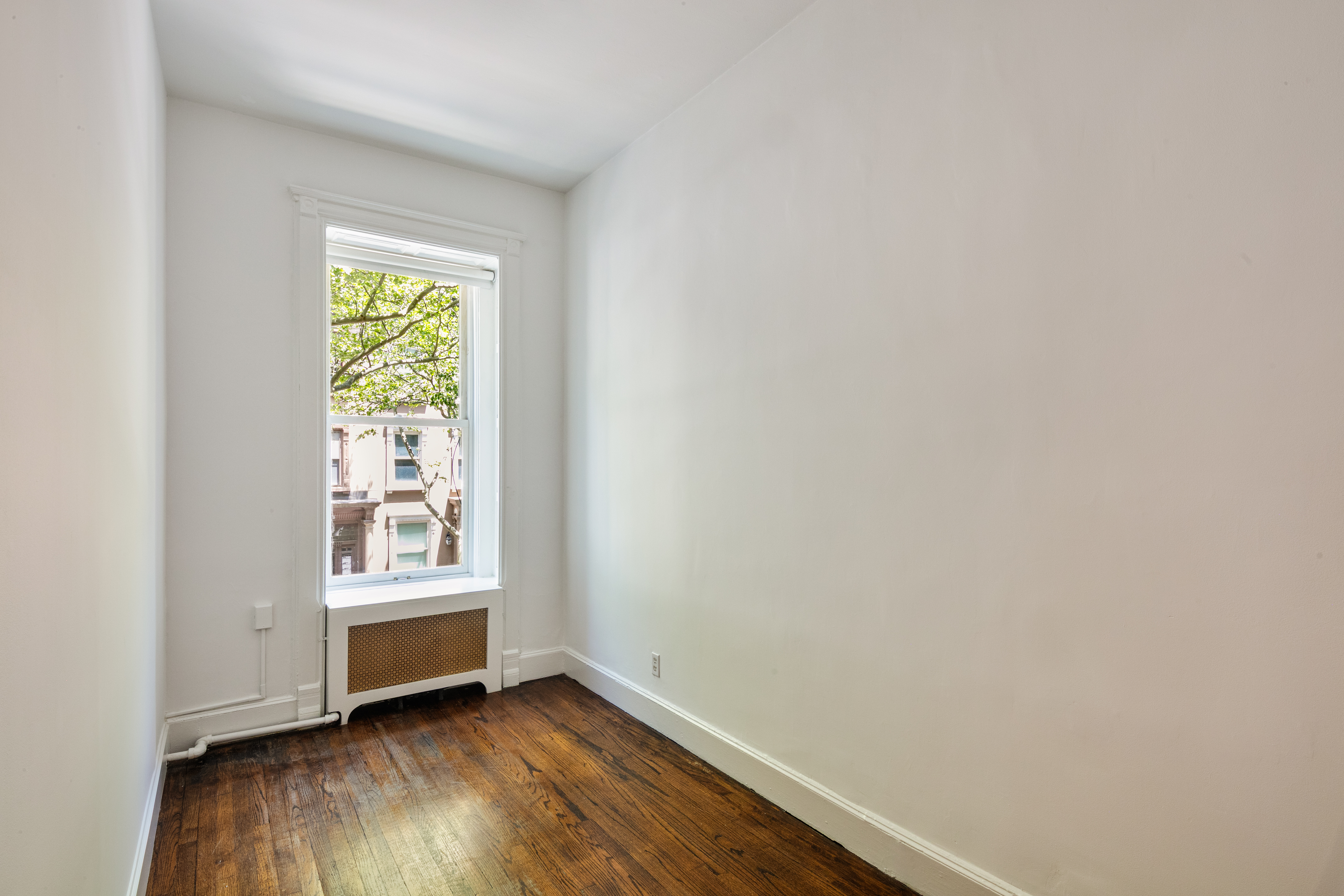 112 West 78th Street, Unit PARLOR Manhattan, NY 10024 - Photo 31 of 37 a view of an empty room with a window and wooden floor
