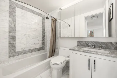 a bathroom with a granite countertop sink toilet and shower