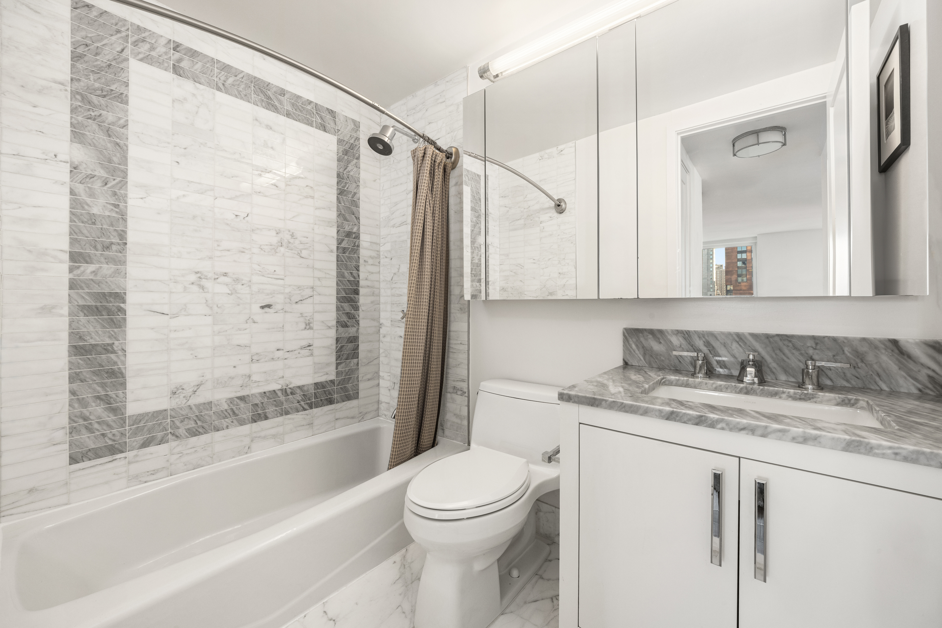 200 East 94th Street, Unit 2309 Manhattan, NY 10128 - Photo 7 of 17 a bathroom with a granite countertop sink toilet and shower