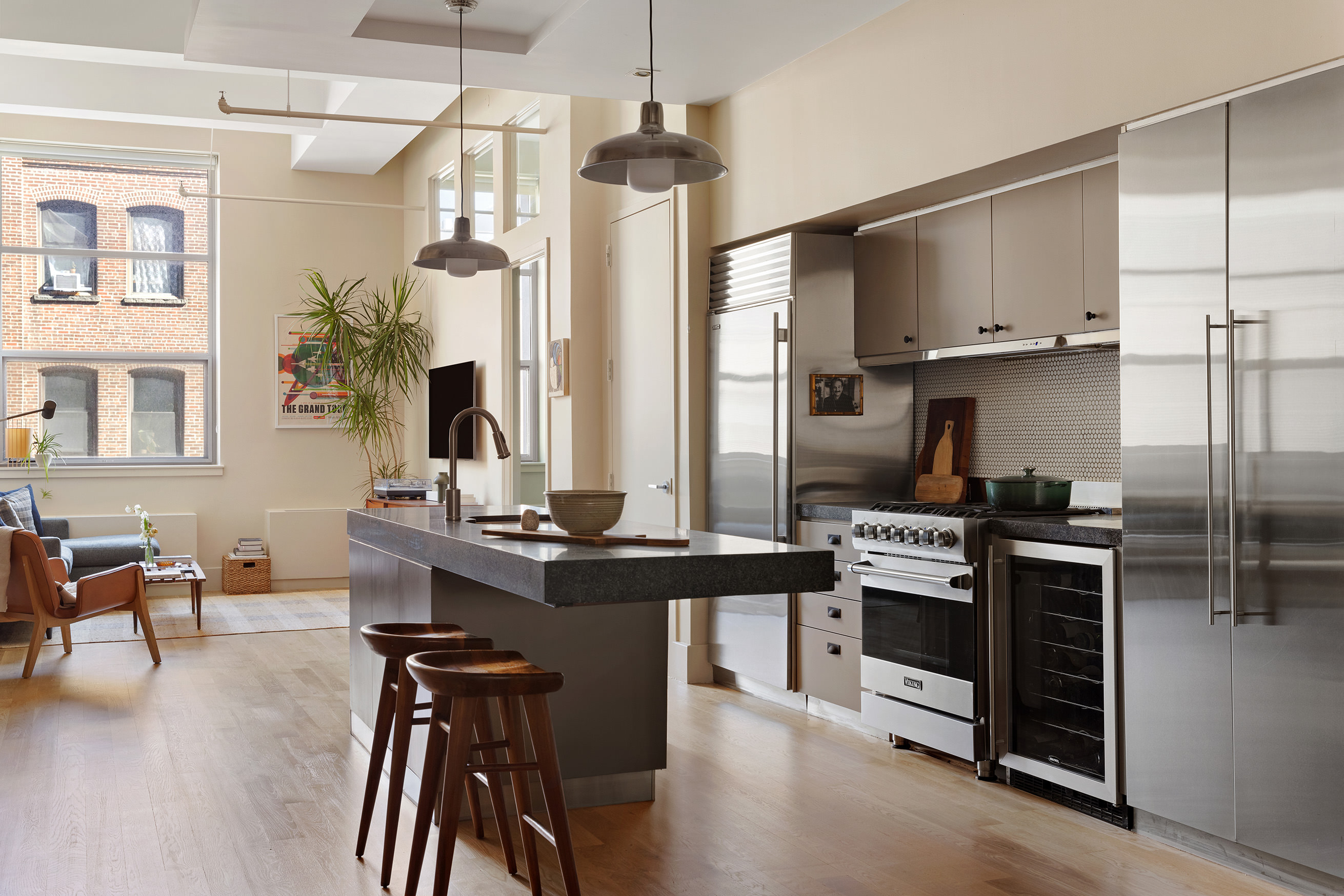 a kitchen with stainless steel appliances kitchen island granite countertop a table chairs in it and wooden floors