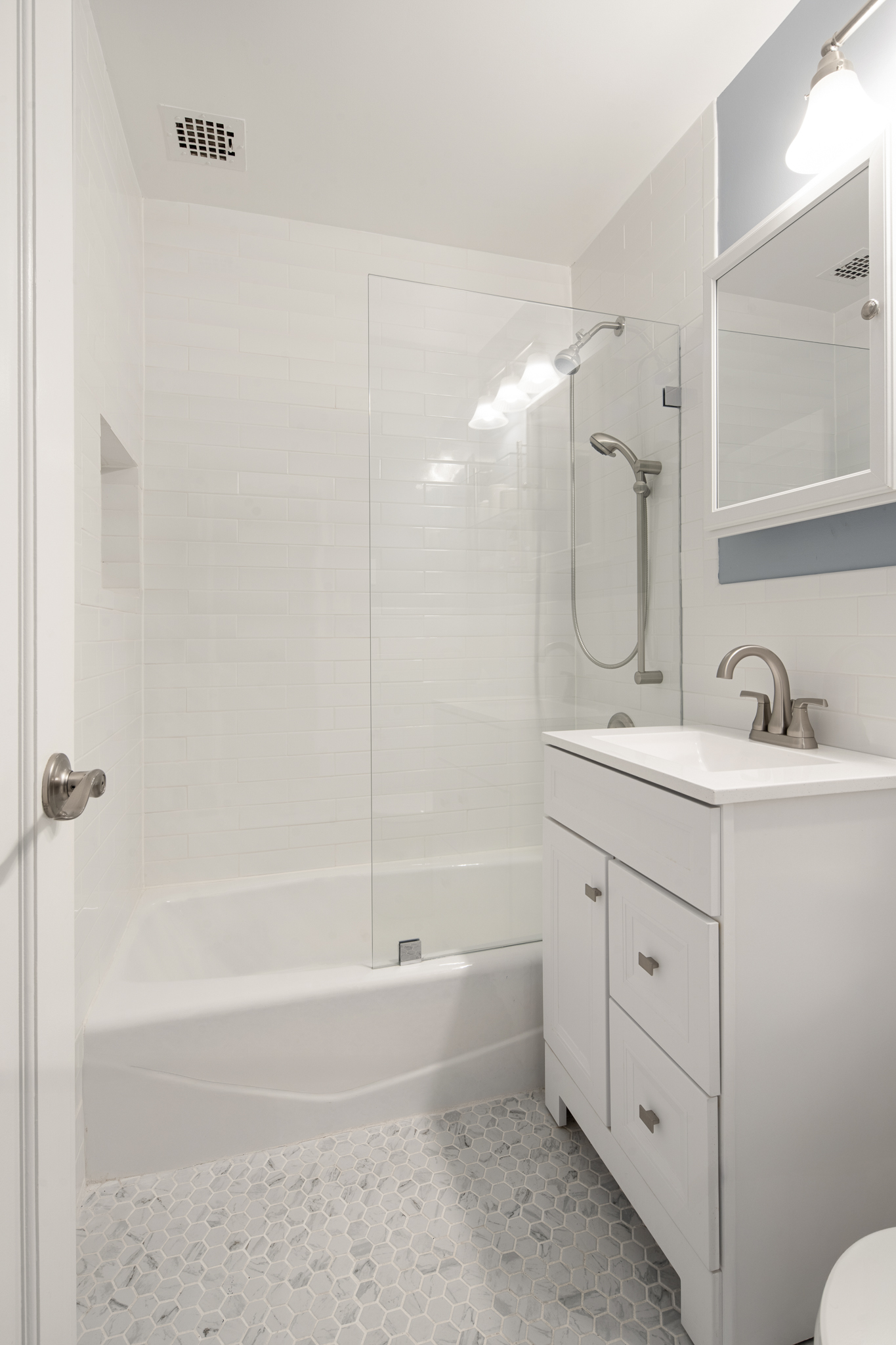 23 East 10th Street, Unit 3C Manhattan, NY 10003 - Photo 5 of 15 a bathroom with a double vanity sink mirror and bathtub