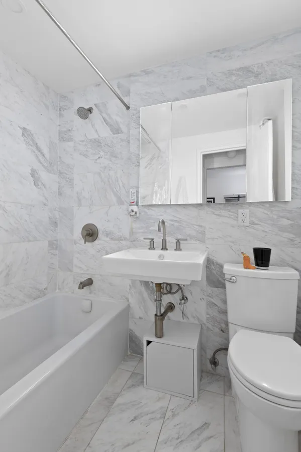 a bathroom with a sink toilet a mirror and bathtub