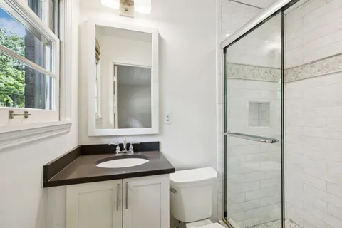 a bathroom with a granite countertop sink toilet and shower
