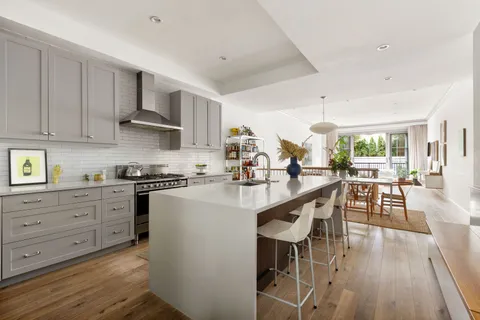 a kitchen with stainless steel appliances a white table and chairs in it