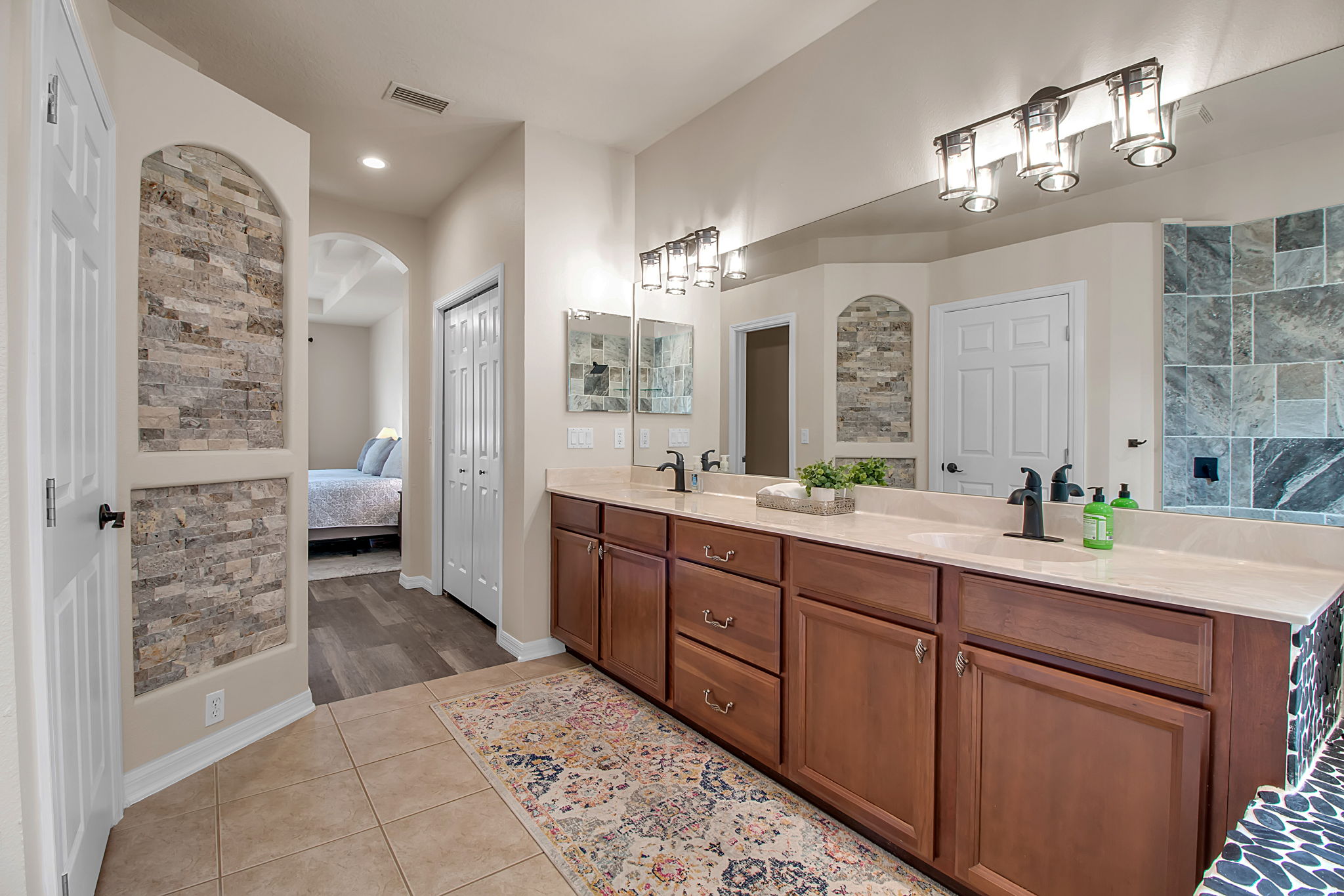 6106 34th Court East Bradenton, FL 34203 - Photo 38 of 69 a spacious bathroom with a granite countertop sink a mirror and a shower