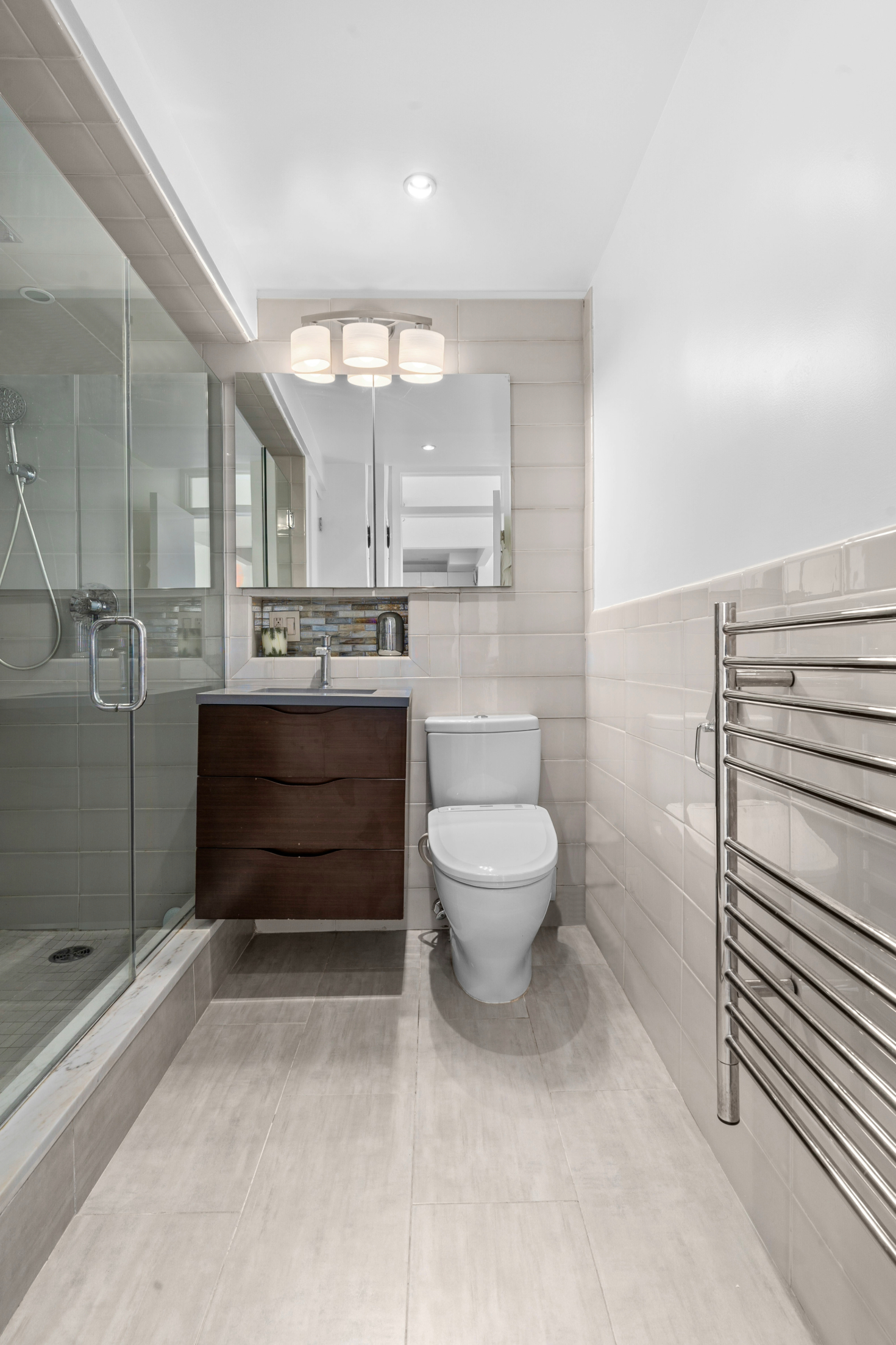 61 Jane Street, Unit 19E Manhattan, NY 10014 - Photo 4 of 9 a bathroom with a toilet sink and mirror