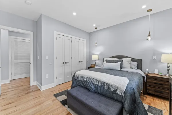 a bedroom with a bed and wooden floor