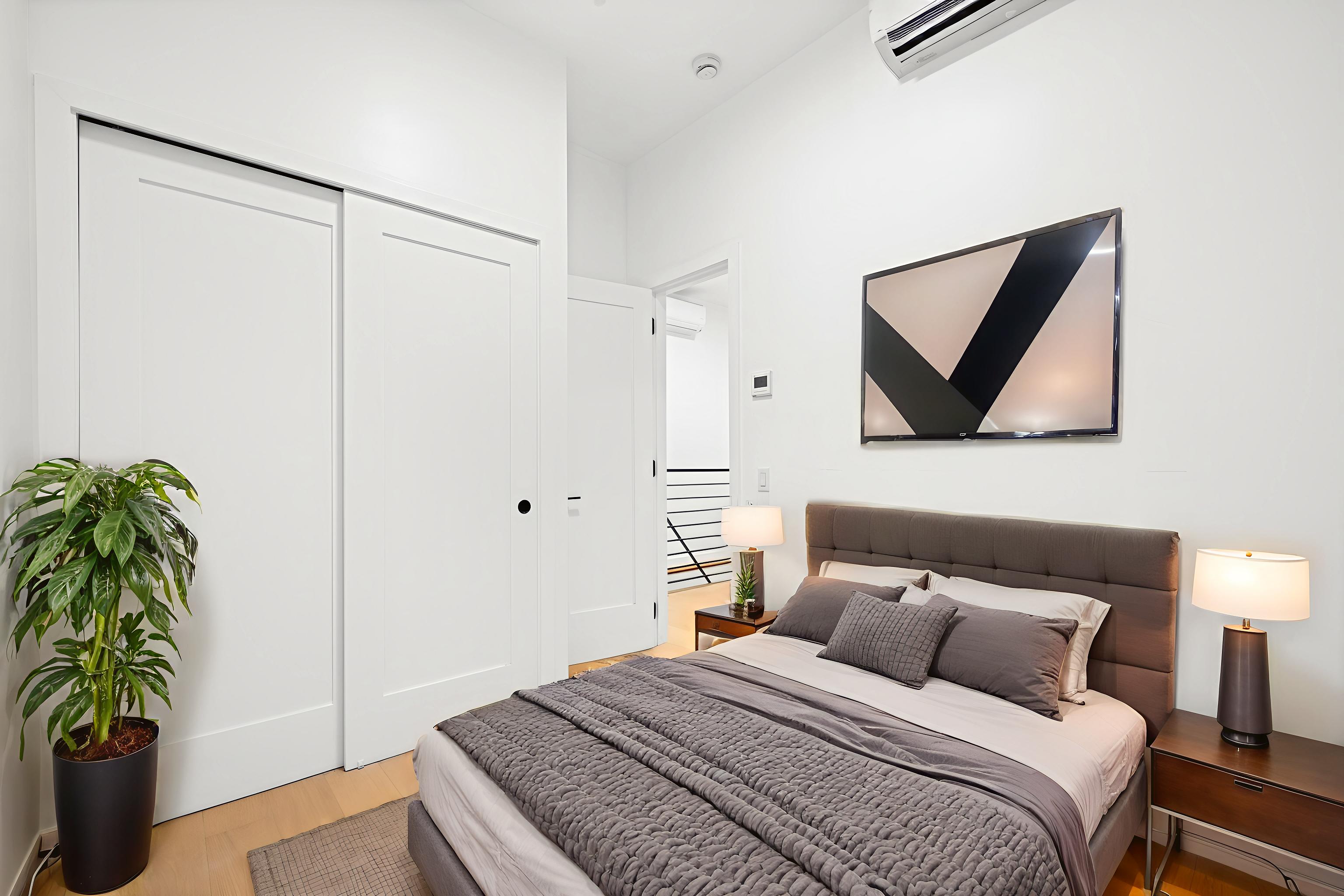 433 Wythe Avenue, Unit 4A Brooklyn, NY 11249 - Photo 3 of 5 a bedroom with a bed and a potted plant