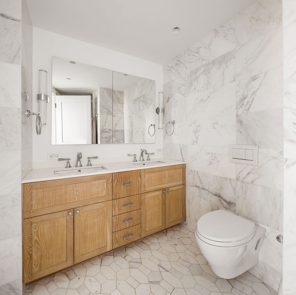 303 Greenwich Street, Unit 8DE Manhattan, NY 10013 - Photo 10 of 20 a bathroom with a toilet sink and mirror