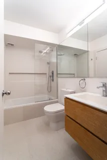 a bathroom with a bathtub shower sink vanity and toilet