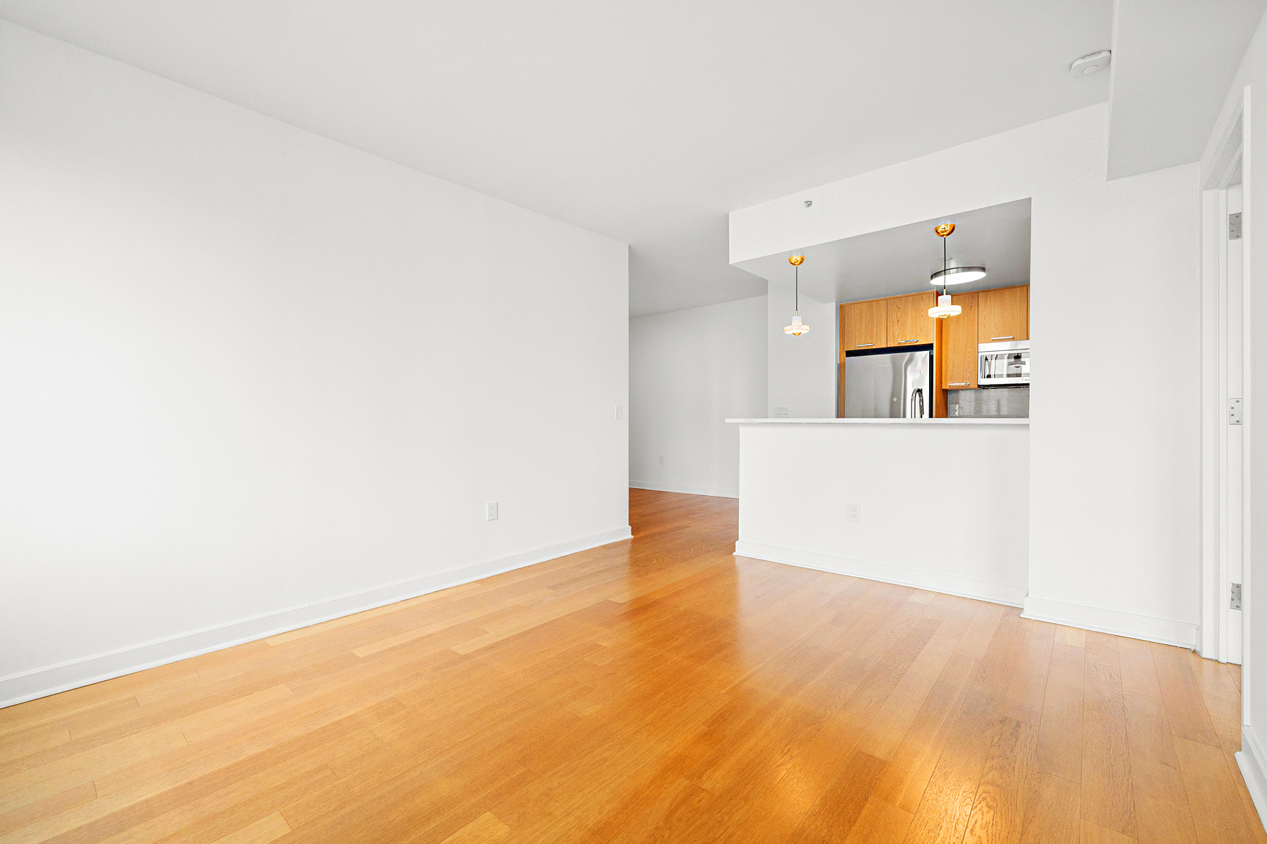 425 Main Street, Unit 9F Manhattan, NY 10044 - Photo 12 of 15 an empty room with wooden floor and windows