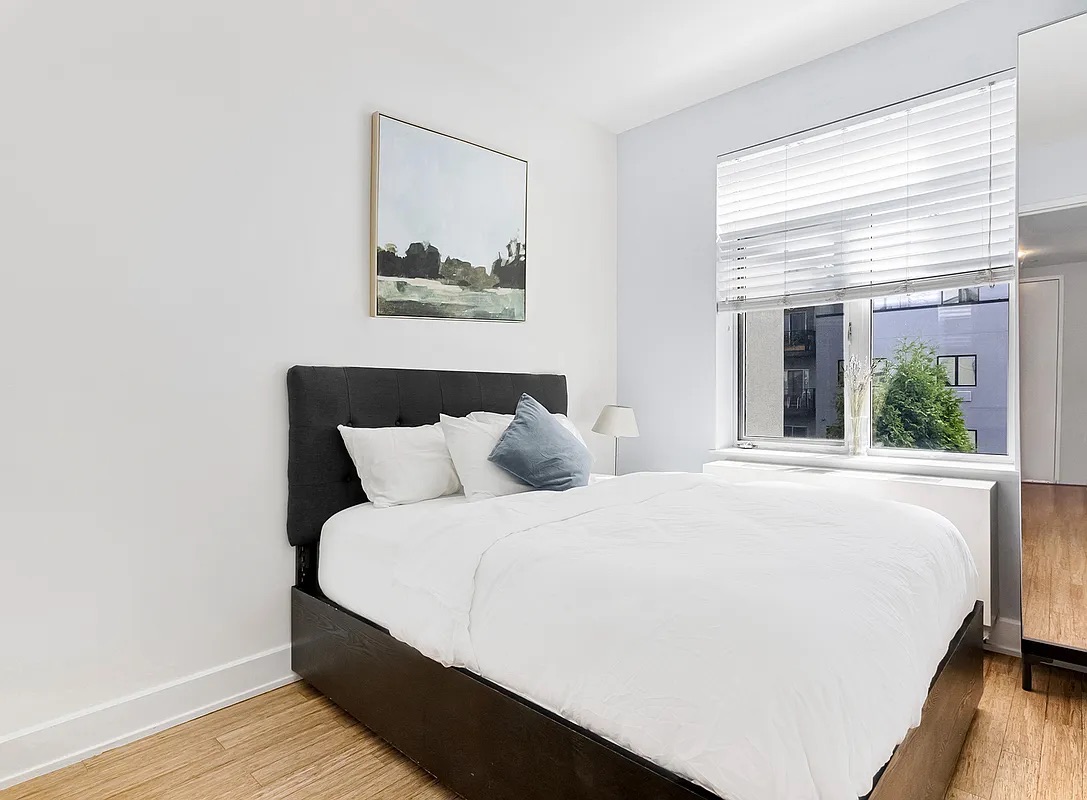 12 Monitor Street, Unit 3B Brooklyn, NY 11222 - Photo 6 of 11 a large bed sitting in a bedroom next to a window