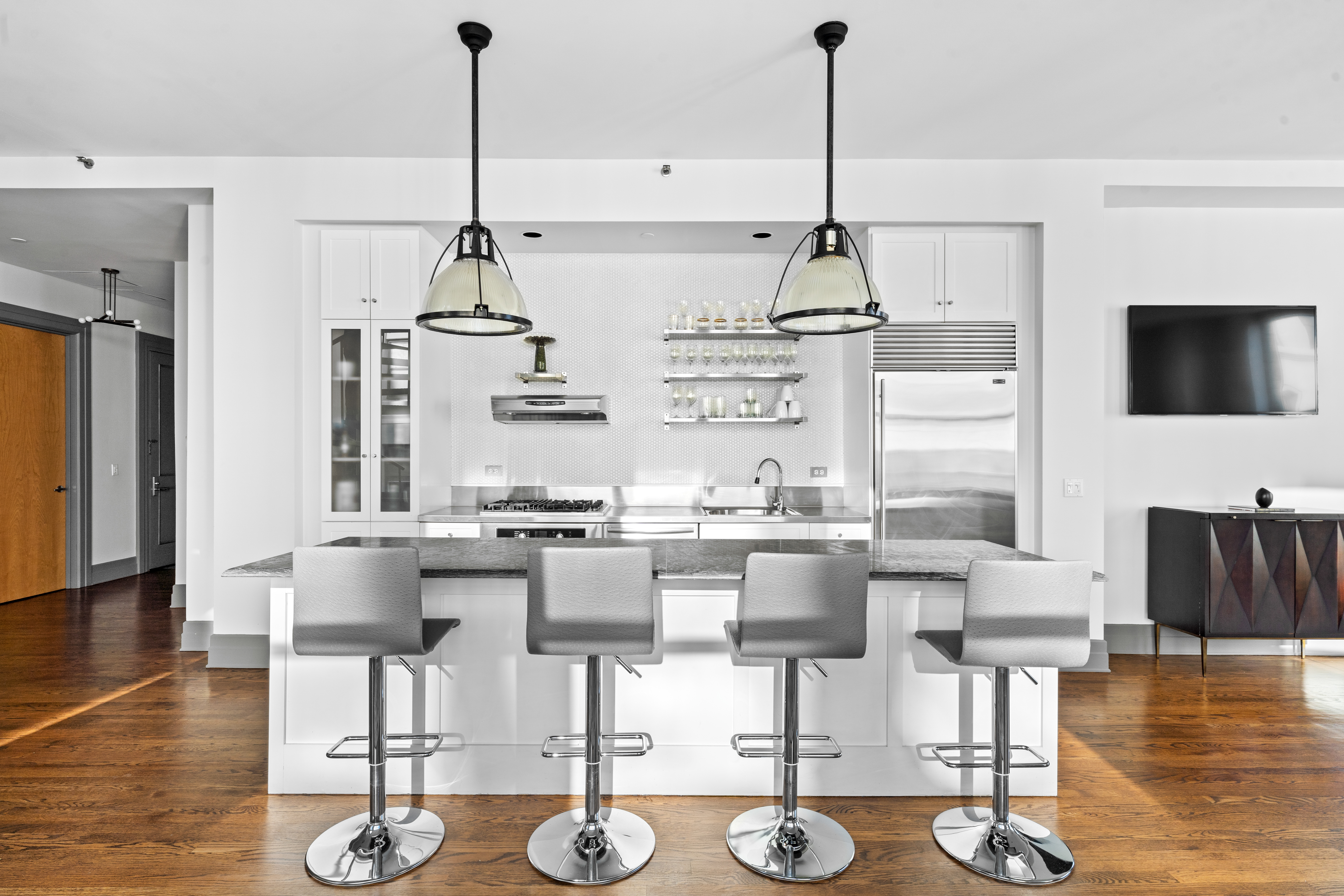 30 Main Street, Unit PHB Brooklyn, NY 11201 - Photo 6 of 33 a kitchen with stainless steel appliances kitchen island granite countertop a table and chairs in it