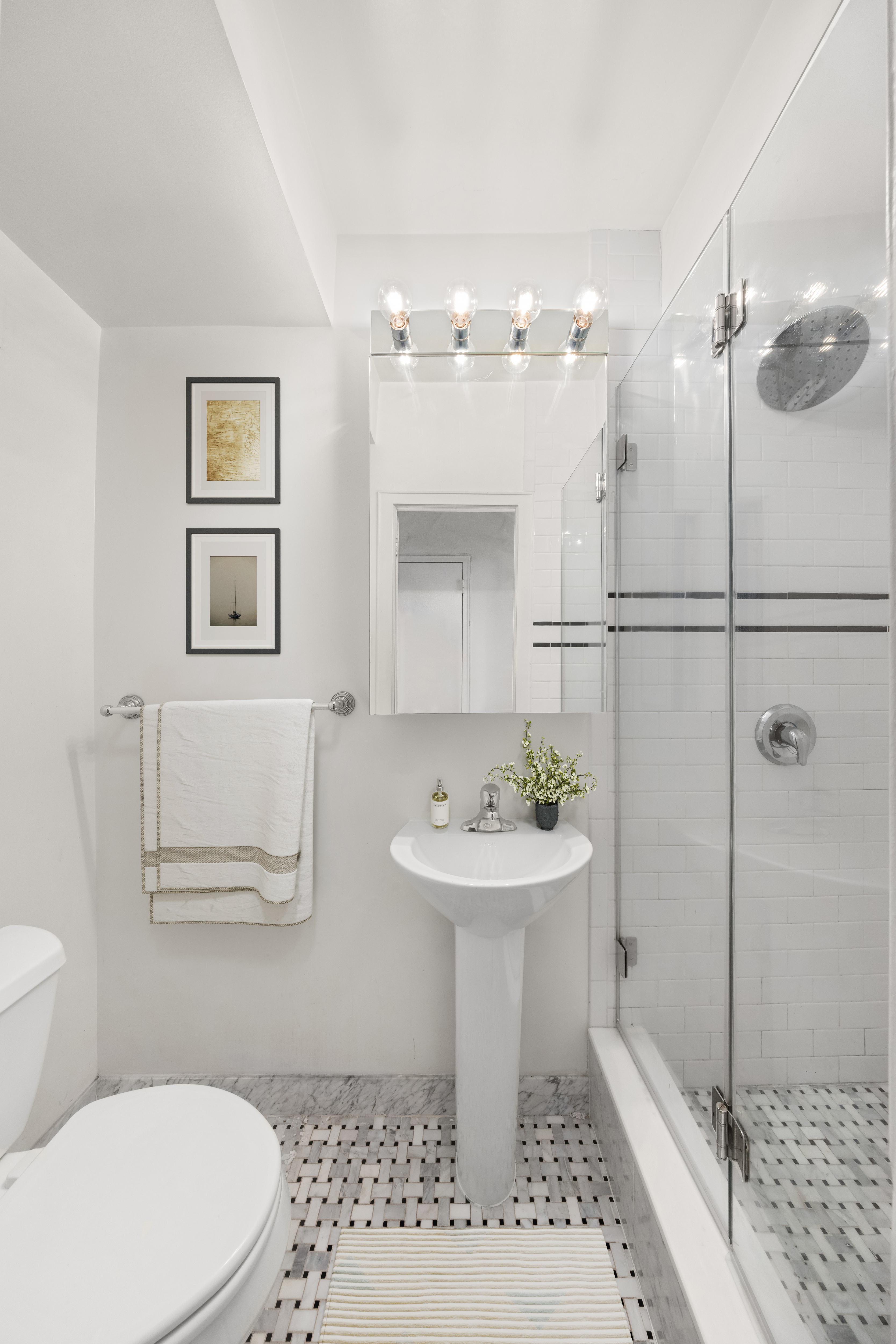 63 East 9th Street, Unit 6F Manhattan, NY 10003 - Photo 8 of 9 a bathroom with a sink a toilet a mirror and shower