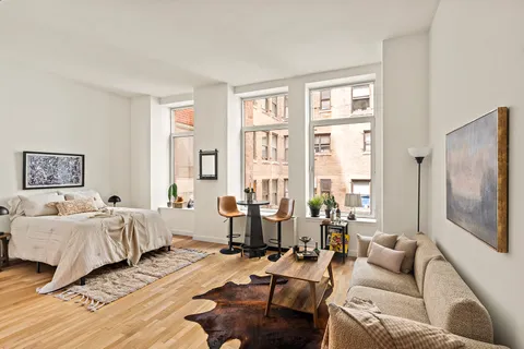 a bedroom with furniture and a large window