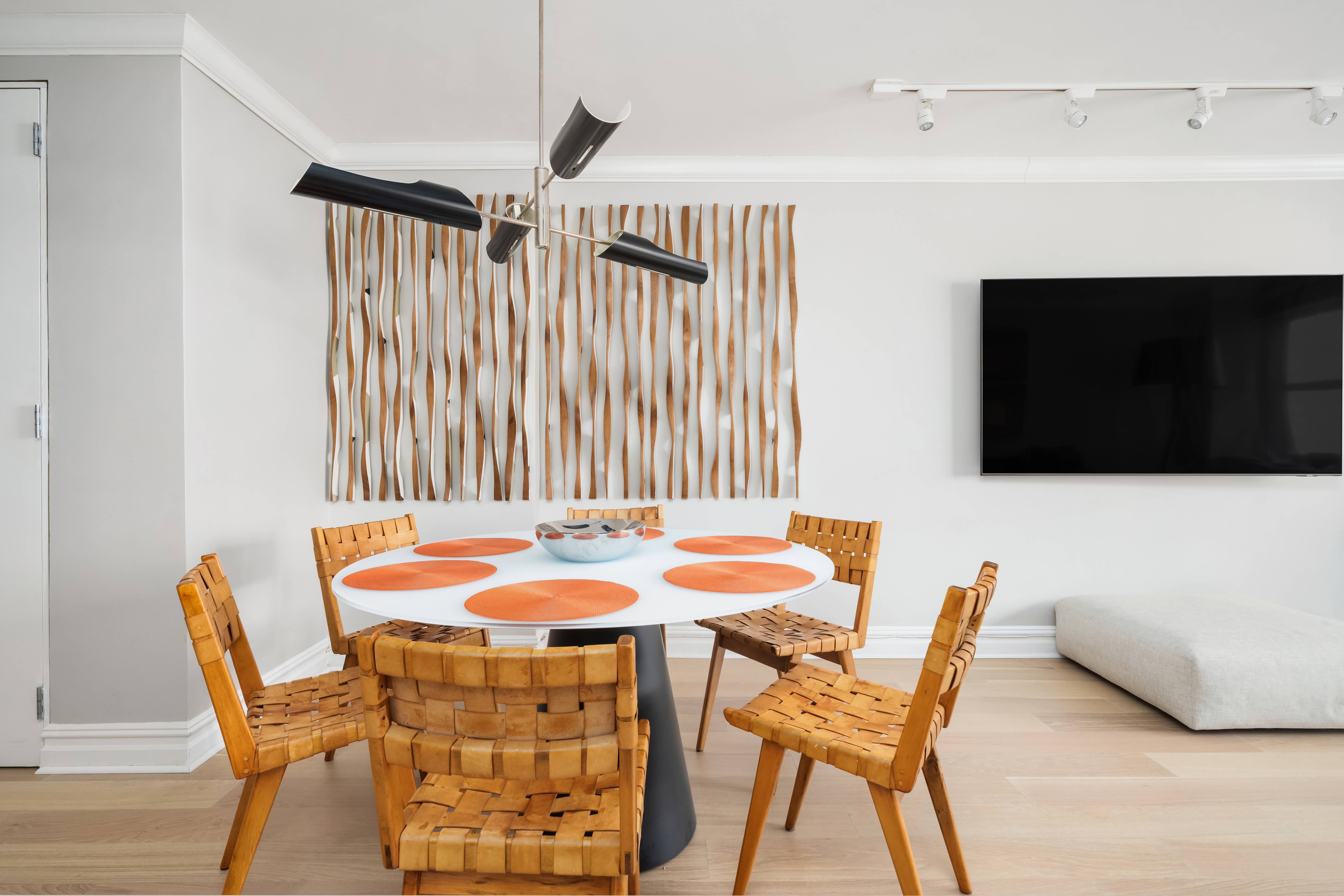 77 West 55th Street, Unit 9F Manhattan, NY 10019 - Photo 6 of 11 a dining room with furniture and a flat screen tv