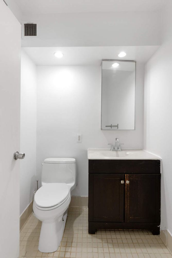 376 Broadway, Unit 8F Manhattan, NY 10013 - Photo 16 of 20 a bathroom with a toilet a sink and mirror