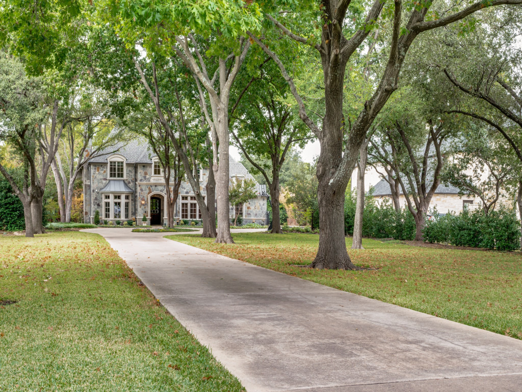 a front view of a house with a yard and trees