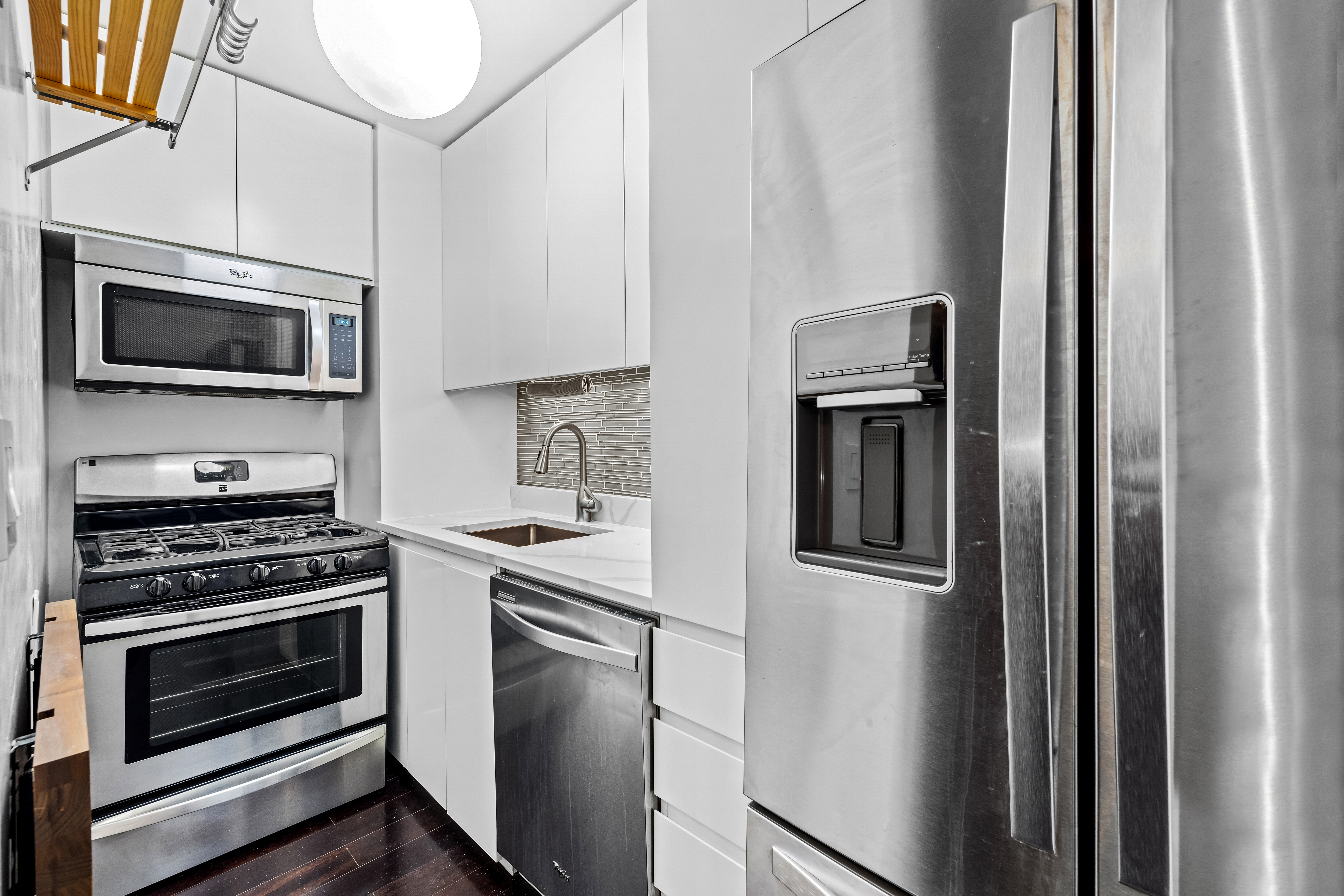 139 East 33rd Street, Unit 3M Manhattan, NY 10016 - Photo 5 of 11 a kitchen with stainless steel appliances a stove a microwave and a refrigerator