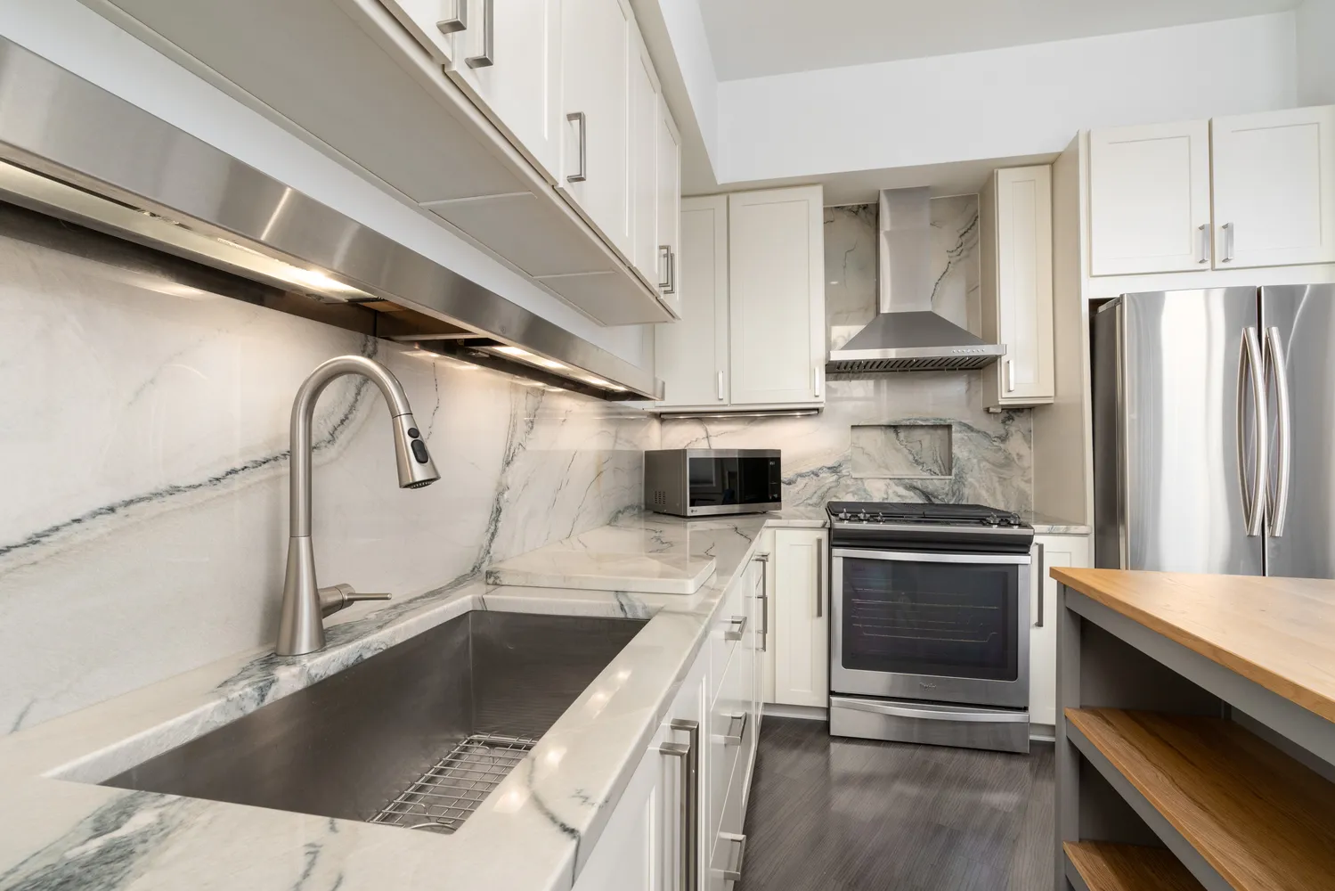 a kitchen with granite countertop a sink stainless steel appliances and cabinets
