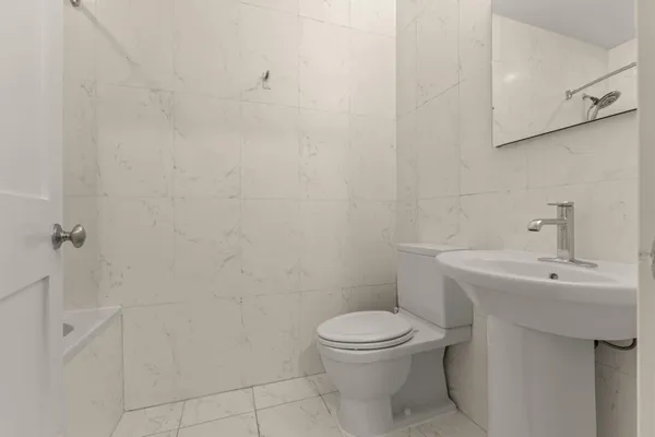 a white toilet sitting next to a white sink