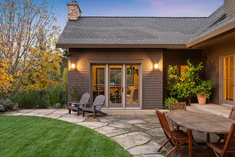 a view of a house with backyard sitting area and garden
