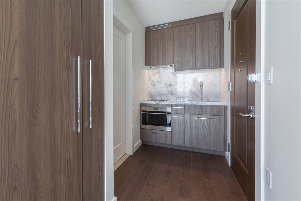 40 Trinity Place, Unit 1606 Boston, MA 02116 - Photo 7 of 17 a kitchen with white cabinets and white appliances