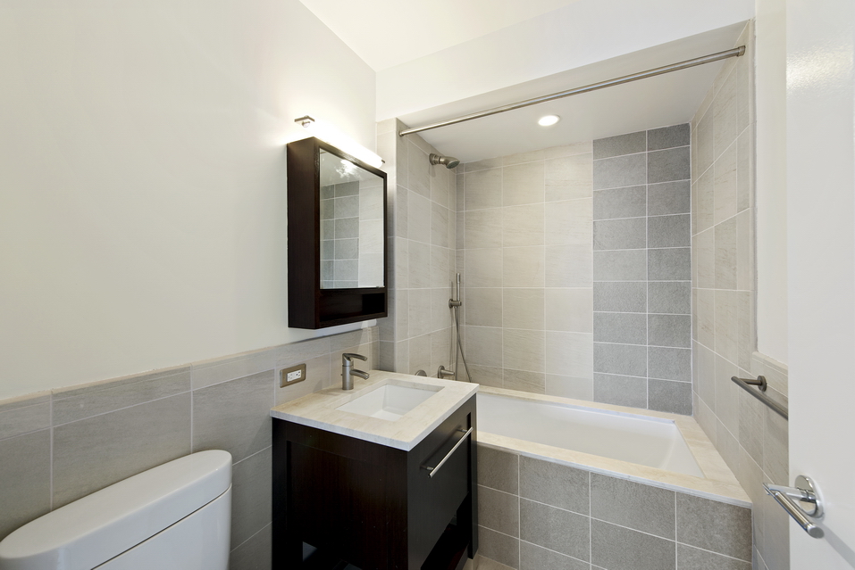 101 West 24th Street, Unit 26A Manhattan, NY 10011 - Photo 10 of 21 a bathroom with a bathtub a sink and a mirror