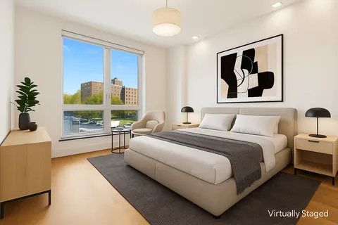 a spacious bedroom with a bed and a large window