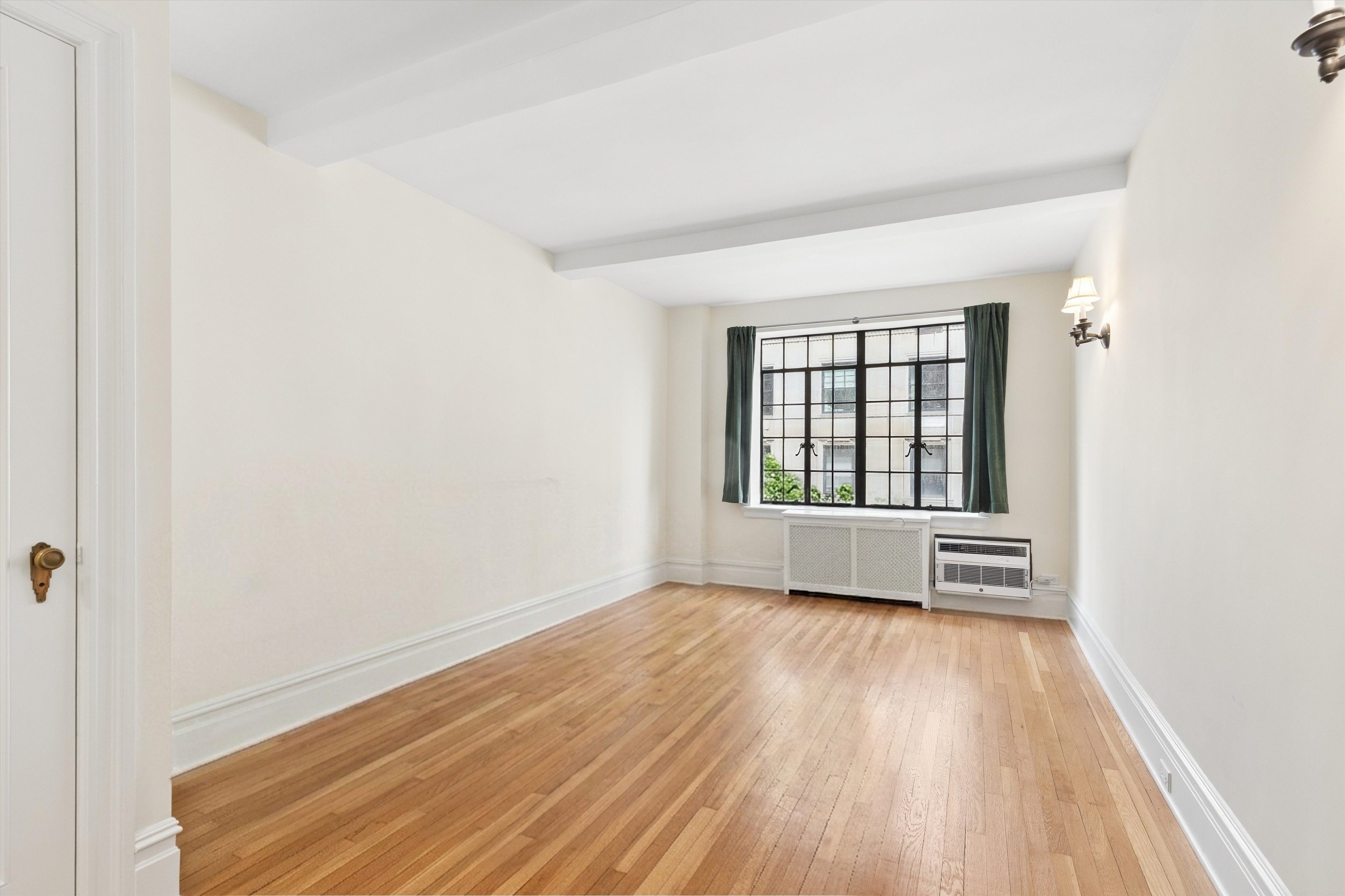 444 East 52nd Street, Unit 3C Manhattan, NY 10022 - Photo 8 of 19 an empty room with wooden floor and windows