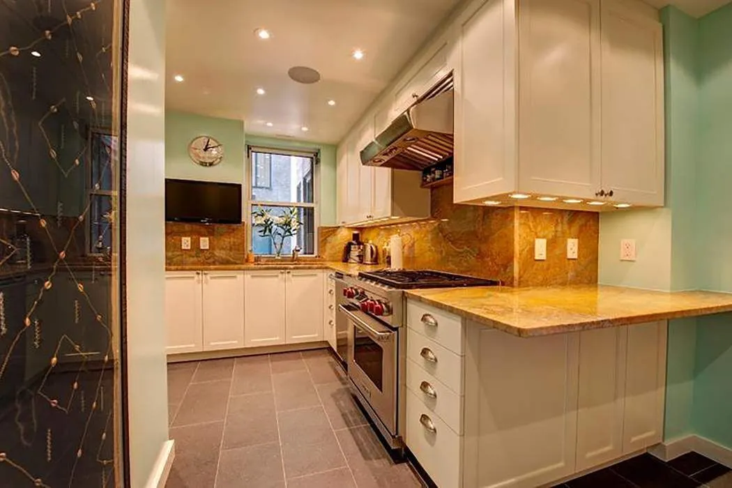 a kitchen with stainless steel appliances granite countertop a stove a sink and a microwave