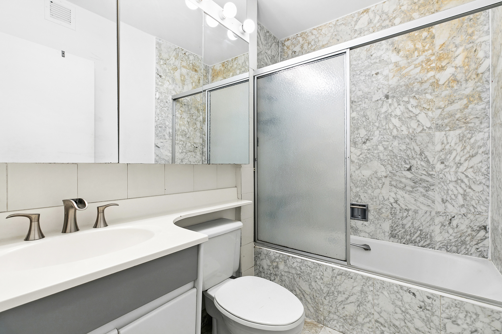 377 Rector Place, Unit 1D Manhattan, NY 10280 - Photo 5 of 6 a bathroom with a sink a toilet and shower