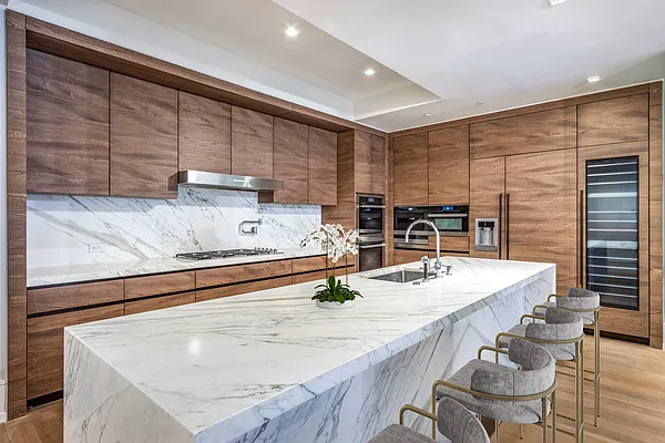 215 Sullivan Street, Unit THC Manhattan, NY 10012 - Photo 8 of 16 a kitchen with stainless steel appliances kitchen island granite countertop a sink and cabinets