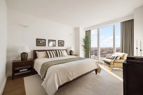 a bedroom with a bed and a large window