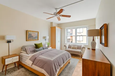 a spacious bedroom with a bed a couch and a window