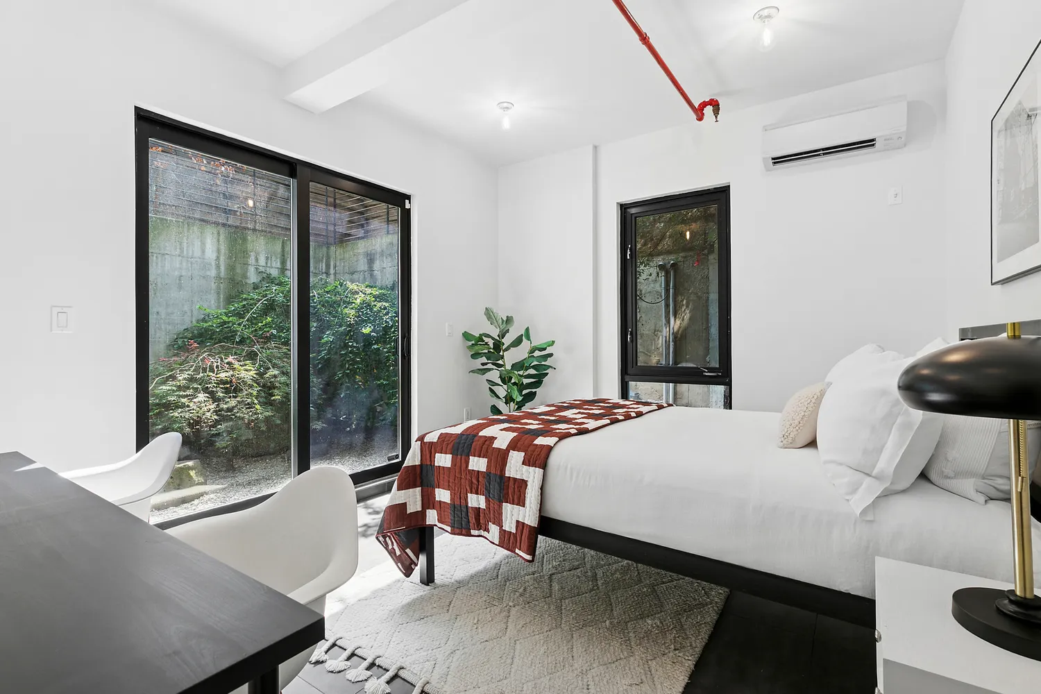 a bedroom with a bed and large windows