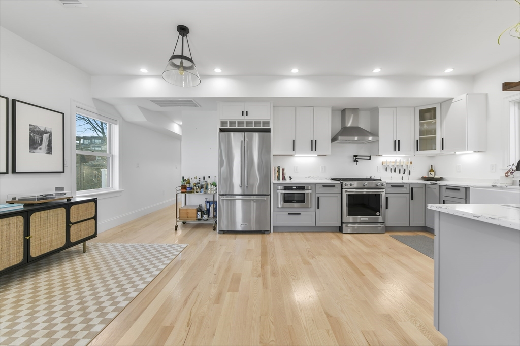 17 Akron Street, Unit 2 Boston, MA 02119 - Photo 6 of 26 a large kitchen with stainless steel appliances kitchen island a large counter top and a view of living room