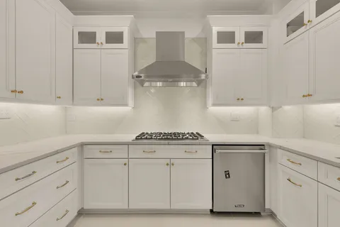 a kitchen with white cabinets and a stove
