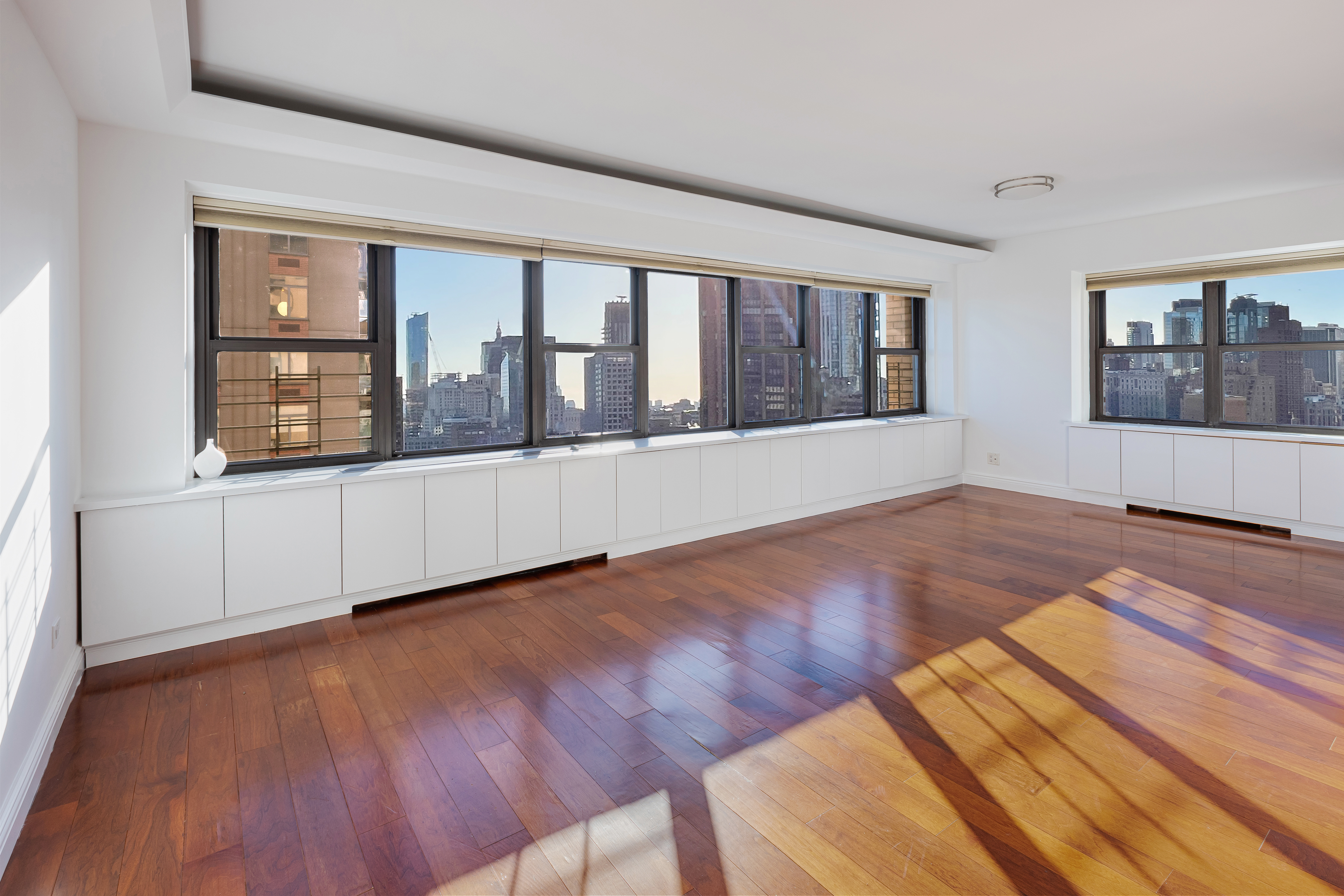 160 East 38th Street, Unit 32A Manhattan, NY 10016 - Photo 2 of 22 a view of an empty room with wooden floor and a window