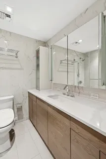 a bathroom with a double vanity sink mirror and toilet