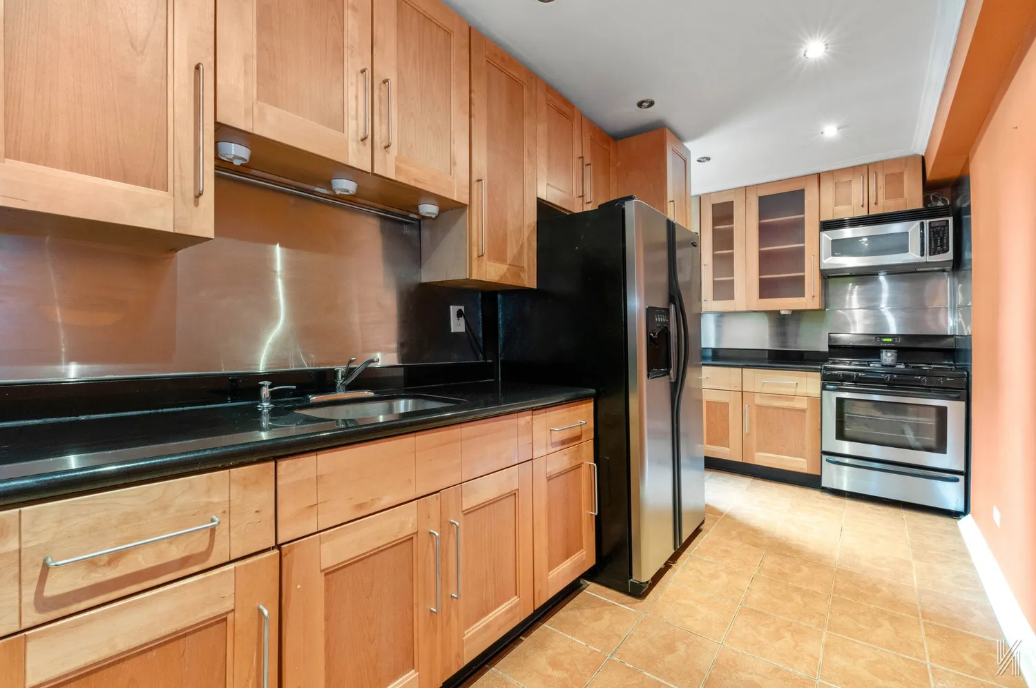 a kitchen with granite countertop a refrigerator and a sink