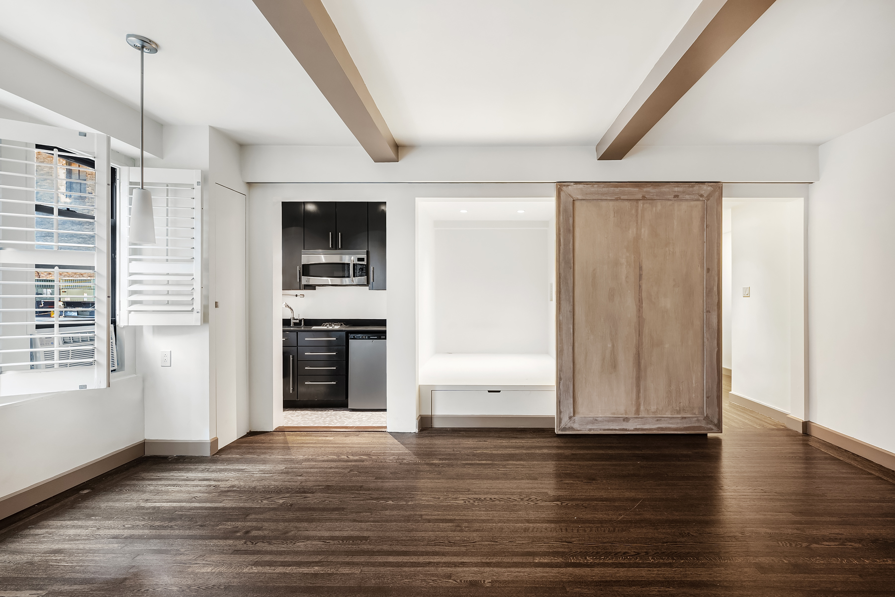 339 East 58th Street, Unit 3J Manhattan, NY 10022 - Photo 2 of 9 a view of a kitchen with wooden floor and a ceiling fan