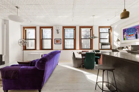 a living room with furniture and floor to ceiling windows