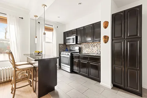a kitchen with stainless steel appliances granite countertop a refrigerator and a stove top oven