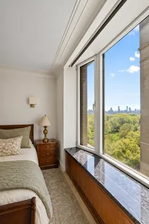 a bedroom with a bed and large windows