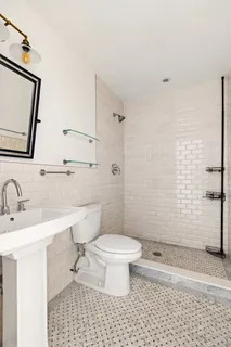 a bathroom with a sink a toilet and shower