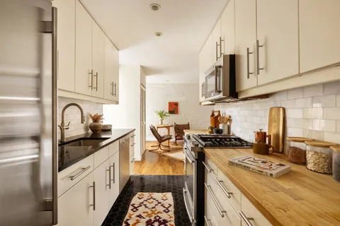 a kitchen with stainless steel appliances granite countertop a stove sink and cabinets
