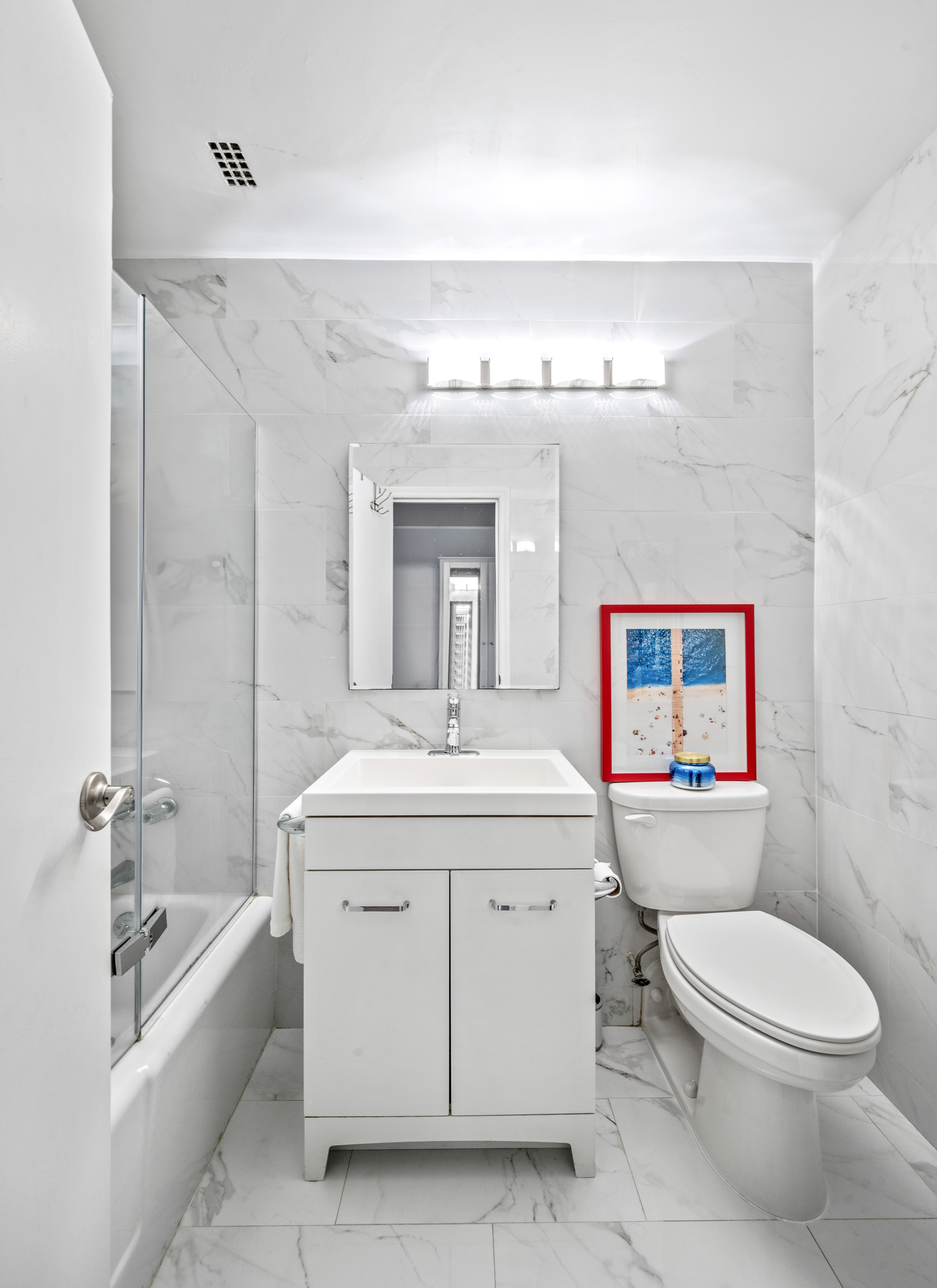 310 East 46th Street, Unit 19F Manhattan, NY 10017 - Photo 8 of 17 a spacious bathroom with a toilet sink and mirror