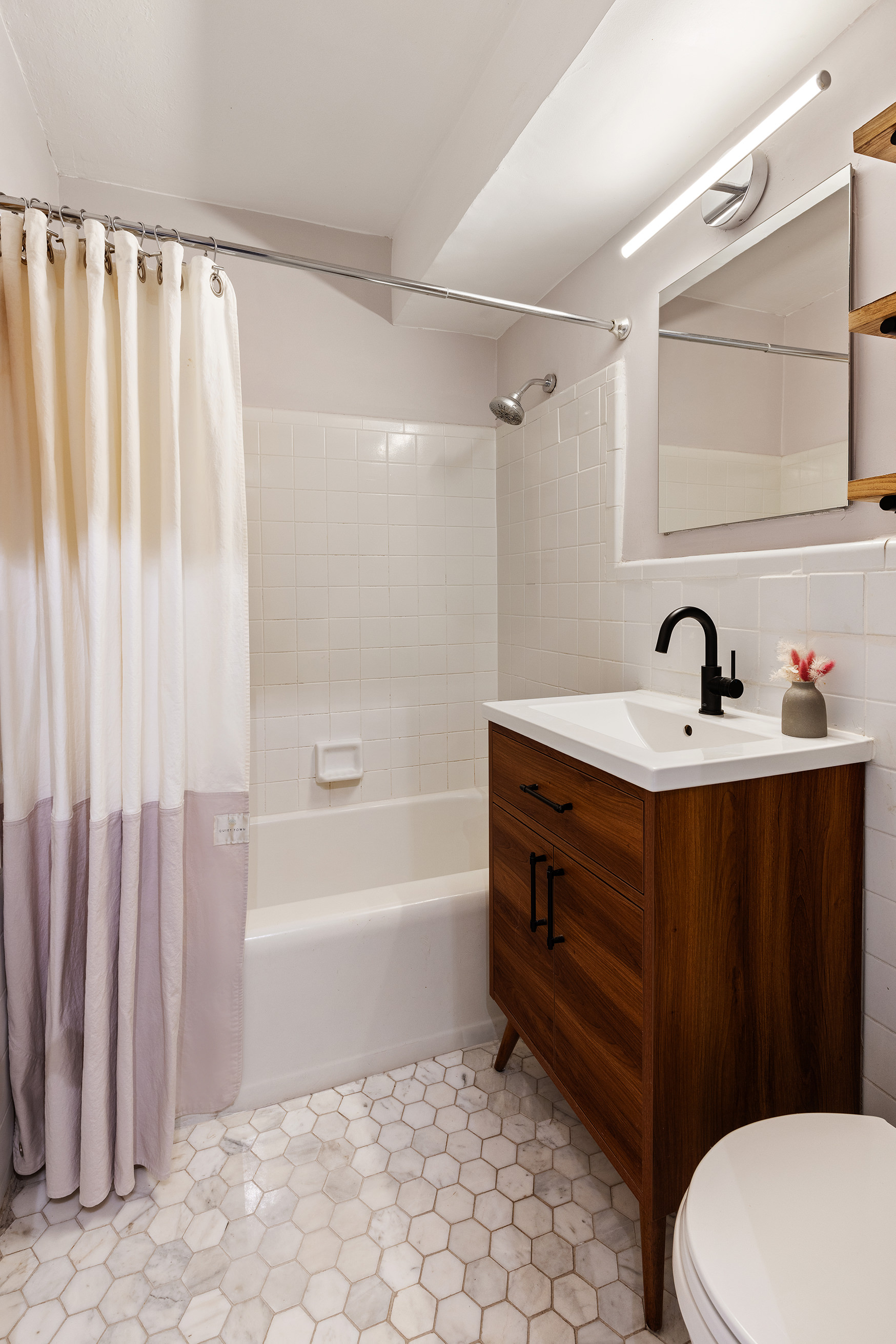 191 Willoughby Street, Unit 4F Brooklyn, NY 11201 - Photo 5 of 6 a bathroom with a sink a toilet a mirror and shower